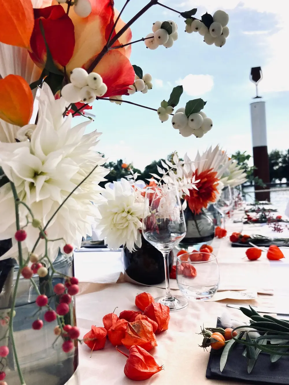 Herbstliche Tischdeko mit Dahlien, Physalis und Weingläsern – Feier direkt am Rhein im Rheingau